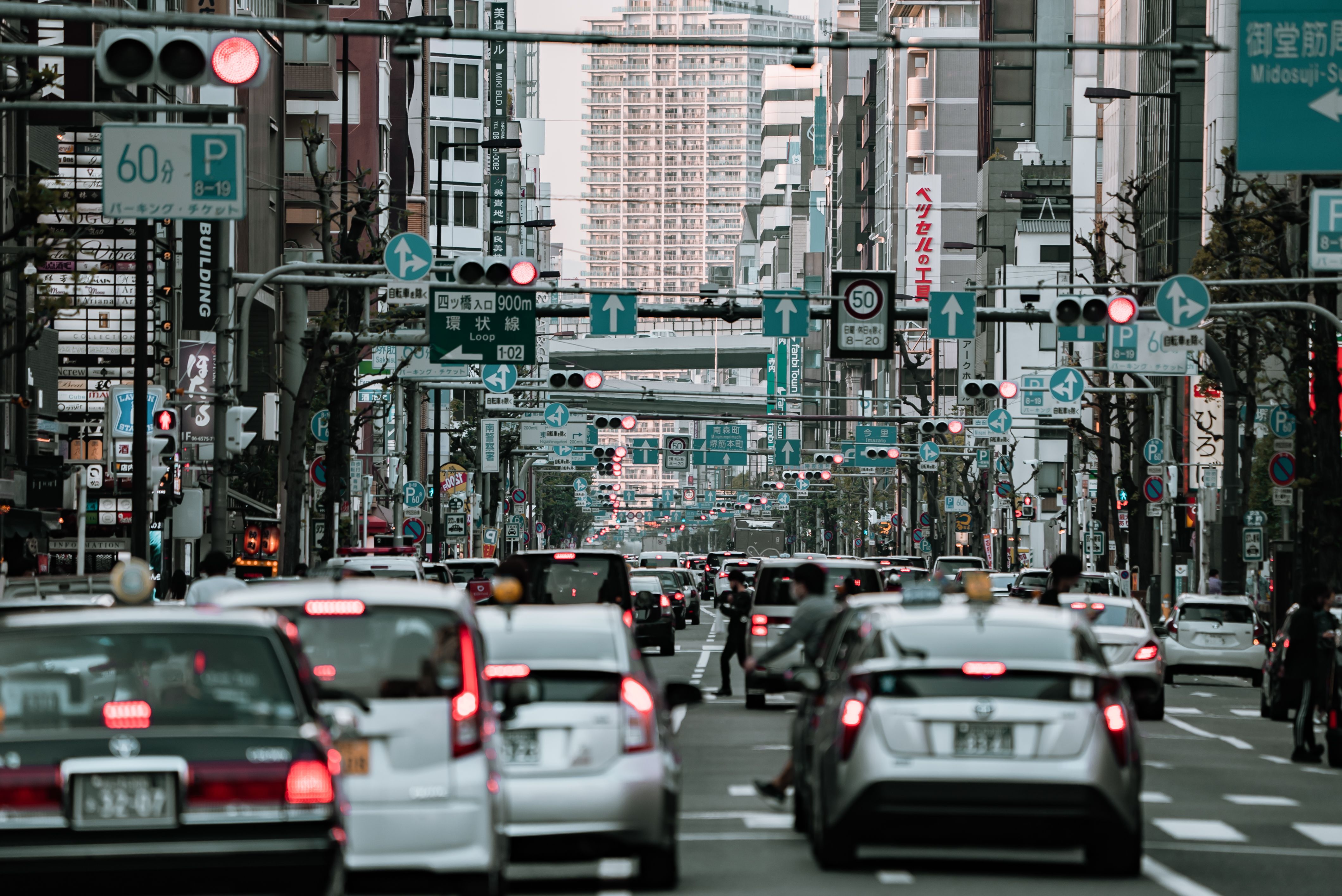  a picture of a busy street in Osaka Japan showing Japanese cars
