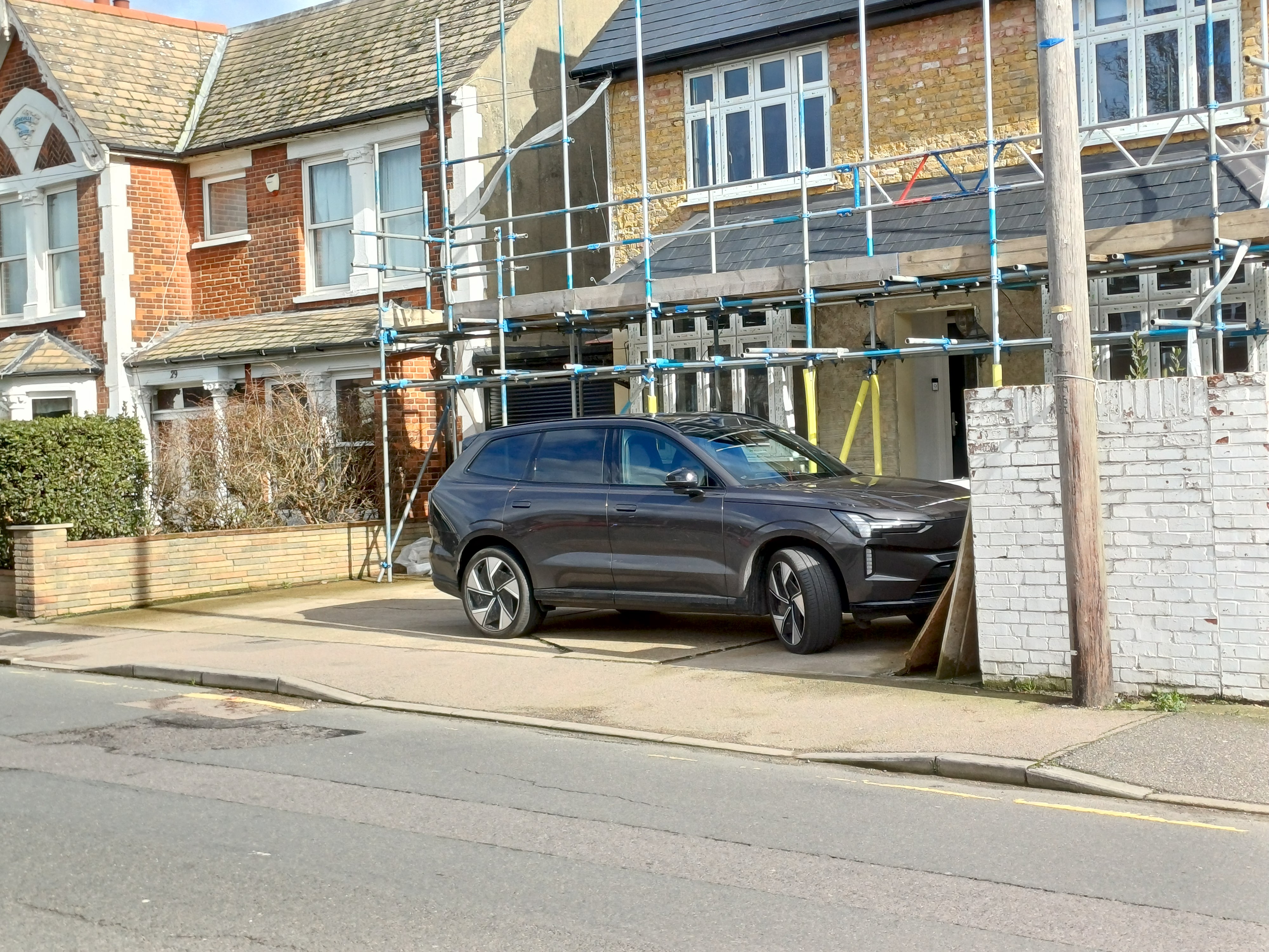  A large SUV parked in a small space, showing how impractical they are